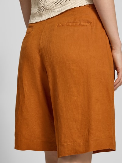 Frauenmodel trägt Bermudas aus Leinen mit Gesäßtaschen von Christian Berg Woman in Rostorange, strukturierte Optik, Regular Fit, Ganzkörperansicht Rückansicht.