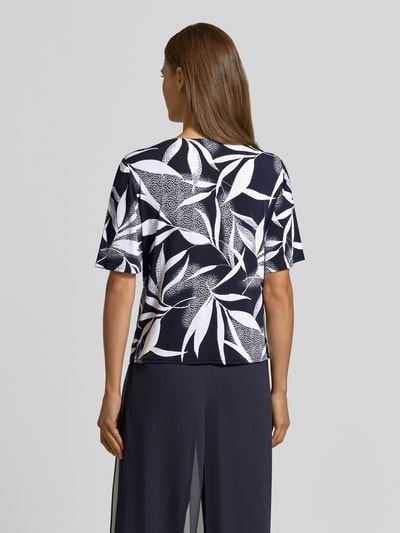 Frauenmodel trägt Regular Fit Blusentop mit Allover-Muster von Vera Mont in Dunkelblau und Weiß mit Blättermotiv, Ganzkörperansicht Rückansicht.