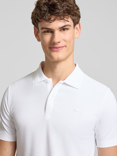 Männermodel trägt weißes Slim Fit Poloshirt mit Logo Modell 'EDMOND' von Ellesse, Material-Mix mit Stretch-Anteil, Nahaufnahme Oberkörper.