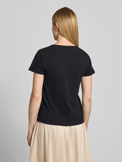 Kobiece model nosi damski t-shirt z bawełny w kolorze czarnym, krój regular fit, okrągły dekolt, model 'RINA' od Soyaconcept, długość tyłu w rozmiarze S: 60 cm, widok całej sylwetki z tyłu.