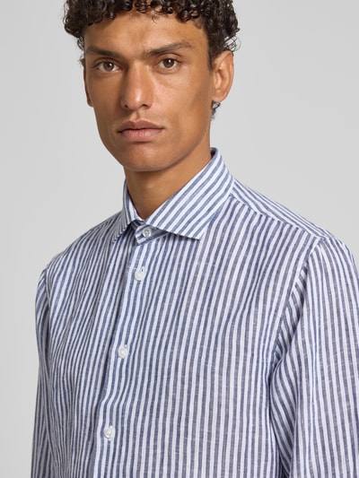 Męski model nosi Modern Fit Freizeithemd aus Leinen mit Kentkragen od Matinique, biało-niebieskie paski, len, krój modern fit, Kent, guziki, długie rękawy, przedłużony tył, długość tyłu w rozmiarze 40: 75 cm, szerokość w rozmiarze 40: 45 cm, długość rękawa w rozmiarze 40: 67 cm, półzbliżenie na górną część ciała