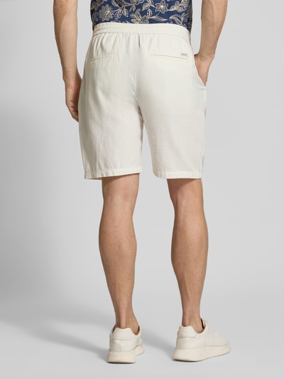 Männermodel trägt Shorts aus Baumwoll-Leinen-Mix Modell 'FAVE' von Scotch & Soda in Beige, Regular Fit, elastischer Bund, Ganzkörperansicht Rückansicht. Bundweite 42 cm, Innenbeinlänge 21 cm, Größe 32.