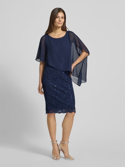 Kobiece modelka nosi Knielanges Cocktailkleid mit Paillettenbesatz von SWING, dopasowany krój, długość do kolan, okrągły dekolt, cekinowe obszycie, efekt podpalania, granatowe odcienie, tekstura koronki, długość tyłu 95 cm, szerokość klatki piersiowej 36 cm, całkowita widok z przodu.