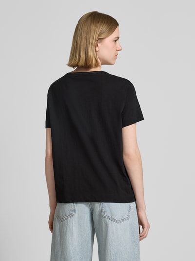 Frauenmodel trägt Relaxed Fit T-Shirt aus reiner Baumwolle von s.Oliver RED LABEL in Schwarz, Melange-Optik, Jersey-Textur, Ganzkörperansicht Rückansicht.