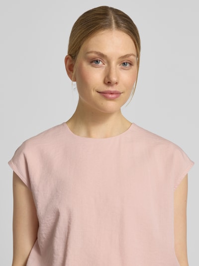 Frauenmodel trägt Bluse mit Rundhalsausschnitt und Kappärmeln von Jake*s Collection in zartem Rosa, gerader Schnitt, Nahaufnahme Oberkörper.