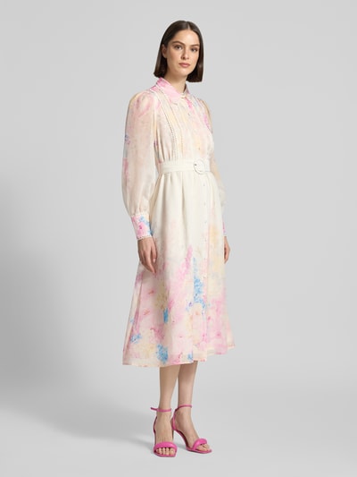Frauenmodel trägt Midikleid aus Lyocell-Mix Modell 'Florence' von YAS mit floraler Allover-Print, Umlegekragen, Knopfleiste, Taillierter Passform, Langärmeligem Design und integriertem Gürtel in sanften Pastelltönen, Ganzkörperansicht von vorne.