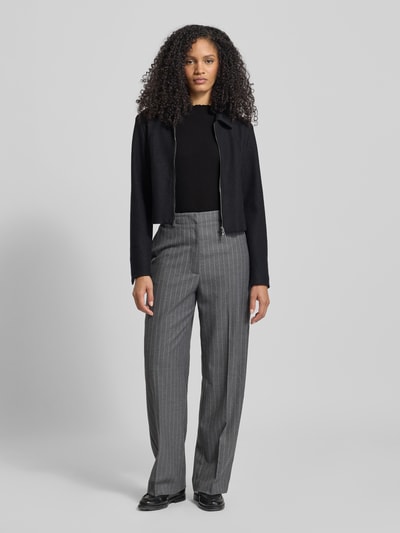 Vrouwenmodel draagt Slim Fit Langarmshirt met Rippstruktur van Tom Tailor Denim in effen zwart met ribstructuur, ronde hals, lange mouwen, frill mouwboord en rompzoom, materiaalverwerking rib; Ganzkörperansicht van voren.
