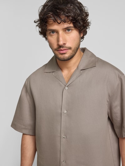 Männermodel trägt Relaxed Fit Freizeithemd aus Hanf-Lyocell-Mix Modell 'ESPINO' von HUGO, unifarben, Resortkragen, Nahaufnahme Oberkörper.