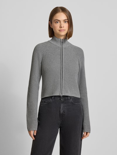 Frauenmodel trägt Slim Fit Jacke aus Baumwoll-Mix Modell 'Dara' von NOISY MAY®, grau, strukturierte Rippenoptik, Zweiwege-Reißverschluss, Stehkragen, Ganzkörperansicht von vorne.
