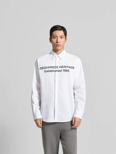 Männermodel trägt Regular Fit Freizeithemd aus Baumwolle von Dsquared2, weiß, schwarze Schrift, Kentkragen, Ganzkörperansicht von vorne.