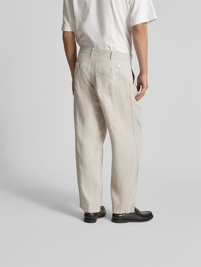 Männermodel trägt Straight Fit Leinenhose von Closed in Beige mit seitlichen Eingrifftaschen, elastischem Bund, Ganzkörperansicht Rückansicht.