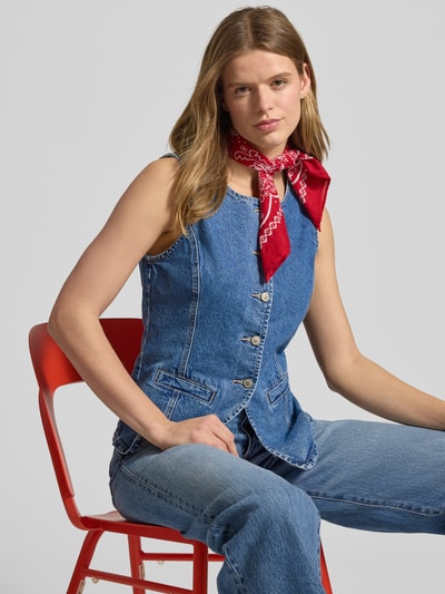 Frauenmodel trägt Jeansweste aus reiner Baumwolle Modell 'GUILINA' von ONLY in Denim-Optik mit Rundhals, Knopfleiste und Paspeltaschen, Nahaufnahme Oberkörper.