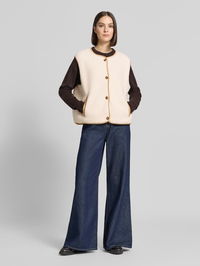 Vrouwenmodel draagt Relaxed Fit bodywarmer met doorlopende knoopsluiting van Christian Berg Woman, Teddybont, ronde hals, mouwloos, zij-steekzakken, Ganzkörperansicht van voren.