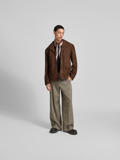 Männermodel trägt Lederjacke aus echtem Ziegenleder von Officine Générale in Braun mit Reverskragen, Pattentaschen, Regular-Fit, durchgängiger Knopfleiste, Ganzkörperansicht von vorne.