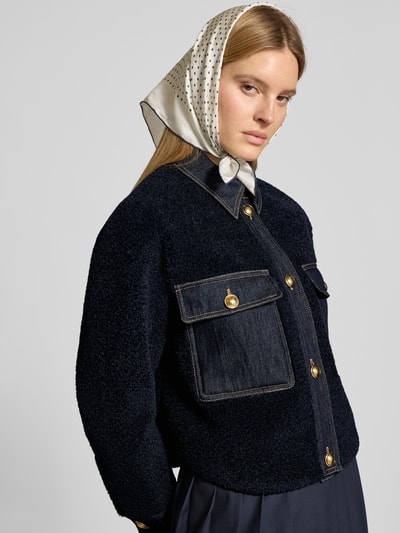 Frauenmodel trägt Bouclè-Jacke mit Kentkragen und Brusttaschen von LUISA CERANO, dunkelblau, strukturierte Oberfläche, Nahaufnahme Oberkörper. Gerader-Schnitt, Knopfverschluss, Rückenlänge 58 cm, Schulterbreite 42 cm, Brustweite 52 cm, Ärmellänge 57 cm.
