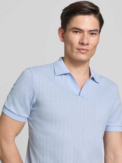 Männermodel trägt Regular Fit Poloshirt mit V-Ausschnitt Modell 'Baronito' von JOOP! Collection, hellblau, Strukturmuster, Nahaufnahme Oberkörper.