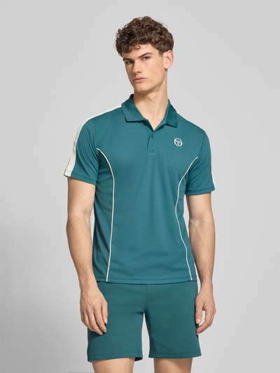 Männermodel trägt Regular Fit Poloshirt mit Logo-Stitching Modell 'EGEO' von SERGIO TACCHINI in Petrol, weiße Akzente, Kurzarm, Ganzkörperansicht von vorne.