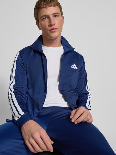 Männermodel trägt 'Trainingsanzug mit elastischen Abschlüssen' von adidas Sportswear, proste kolory, detal z logo, nahaufnahme oberkörper