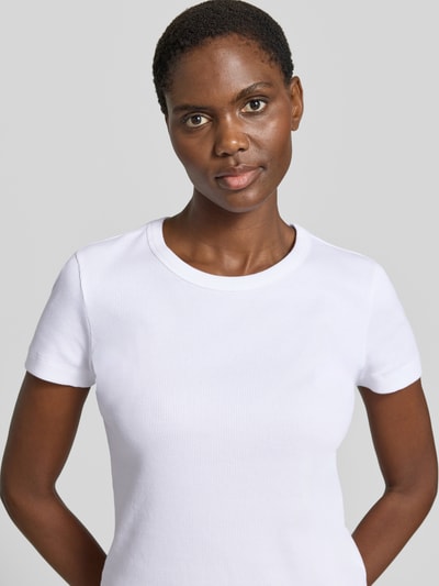 Frauenmodel trägt Slim Fit T-Shirt aus Baumwoll-Mix Modell 'KARDAA' von Armedangels, Optik: Unifarben, Logo-Stitching, Rundhals, Kurzarm, Materialverarbeitung: Feinripp, Nahaufnahme Oberkörper.