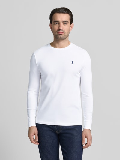 Mężczyzna nosi Custom Slim Fit Longsleeve mit Label-Stitching von Polo Ralph Lauren, biała bawełna, krój slim fit, logo na piersi, okrągły dekolt, długość tyłu 70 cm w rozmiarze M, kolor biały, gładka faktura, pełny widok z przodu
