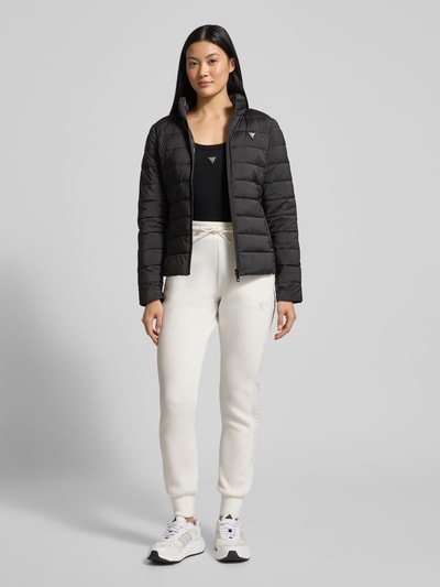 Frauenmodel trägt Body mit Label-Detail Modell 'COLETTE' von Guess Activewear, Schwarz, körpernah, Obermaterial Baumwoll-Elasthan-Mix, Ganzkörperansicht von vorne