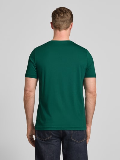 Männermodel trägt T-Shirt mit Rundhalsausschnitt und Label-Stitching von Fynch-Hatton in Dunkelgrün, Reine Baumwolle, Regular-Fit, Rückenlänge bei Größe M 71 cm, Ganzkörperansicht Rückansicht.