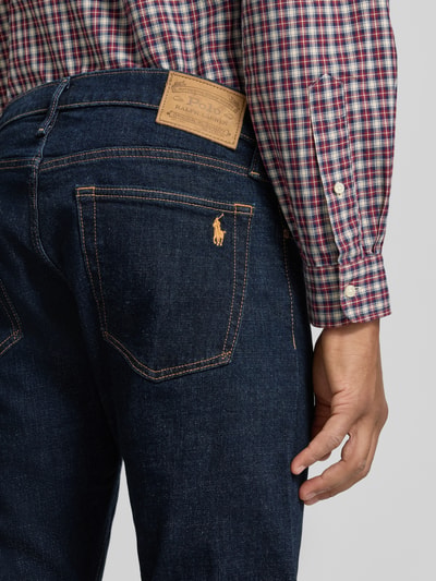 Männermodel trägt Slim Fit Jeans mit Raw Denim Optik von POLO RALPH LAUREN, dunkle Denimfarben, sichtbare Struktur, Detailaufnahme Rückansicht.