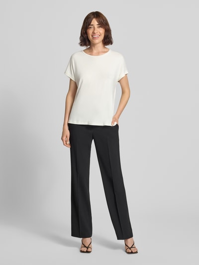 Frauenmodel trägt T-Shirt aus Viskose-Mix mit Rundhalsausschnitt von Christian Berg Woman in Weiß, Regular Fit, schwarze Hose, Ganzkörperansicht von vorne.