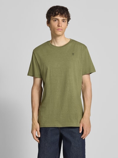 Männermodel trägt T-Shirt mit Logo und Rundhalsausschnitt von G-Star Raw, olivegrün, reine Baumwolle, Regular Fit, Ganzkörperansicht von vorne.