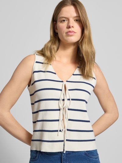 Frauenmodel trägt Weste mit Bindeverschluss und rückseitigem Logo-Stitching von Karo Kauer aus Reine Baumwolle, Gerader-Schnitt, V-Ausschnitt, cremefarben mit dunkelblauen Streifen, glatte Oberfläche, Ganzkörperansicht von vorne.
