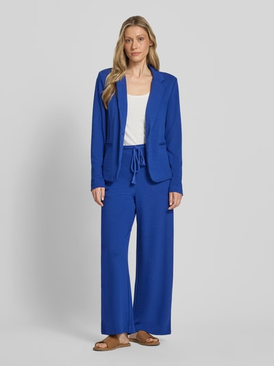 Frauenmodel trägt Wide Fit Stoffhose aus Viskose-Mix Modell 'Lumina' von ICHI mit Strukturmuster und Abnehmbare Stoffkordel, Ganzkörperansicht von vorne. Bundweite 39 cm, Innenbeinlänge 72 cm bei Größe S, Gesäßtaschen.
