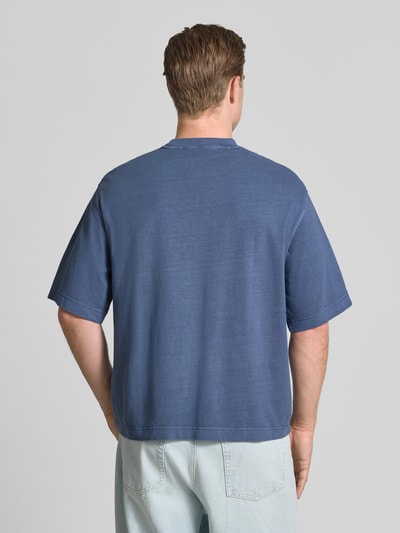 Männermodel trägt Boxy Fit T-Shirt aus reiner Baumwolle Modell 'CORY' von Selected Homme in Blau, lockere Passform, Ganzkörperansicht Rückansicht, Herren T-Shirt von Selected Homme.