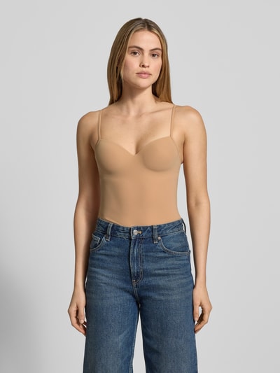 Frauenmodel trägt BH-Top mit gepolsterten, gemoldeten Cups Modell 'ALLURE' von Hanro, Material-Mix mit Stretch-Anteil, körpernahe Passform, verstellbare Träger, sandfarbener Ton, glatte Textur, Ganzkörperansicht von vorne.