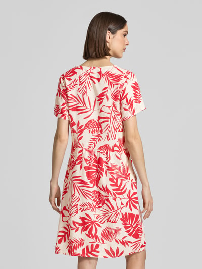 Vrouwenmodel draagt Relaxed Fit jurk uit viscosemix model 'Tara' van ZABAIONE, mix van linnen en viscose, dames, ronde hals, met korte mouwen, ruglengte maat S 96 cm, borstwijdte maat S 49 cm, mouwlengte maat S 21 cm, crème met rood bladerenpatroon, textuur met zichtbare vezels, geheel van achteren.