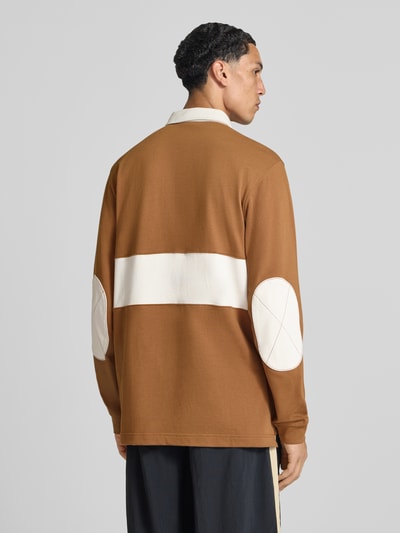Männermodel trägt Loose Fit Sweatshirt aus reiner Baumwolle von Nike in Braun mit weißen Details, Ganzkörperansicht Rückansicht. Herren Sweatshirt.