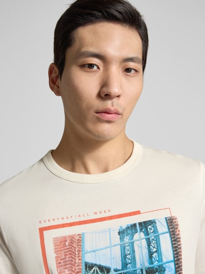 Männermodel trägt Regular Fit T-Shirt aus reiner Baumwolle von Tom Tailor, unifarben mit Foto-Print, kurzarm, Nahaufnahme Oberkörper.
