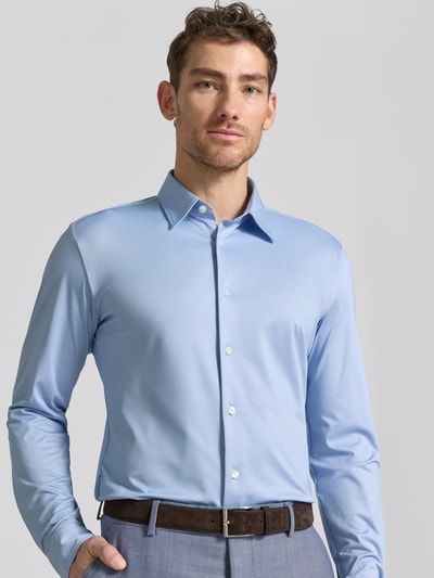 Männermodel trägt Slim Fit Businesshemd mit Kentkragen Modell 'ROAN' von BOSS, Optik: Unifarben, Passform: Slim Fit, Knopfleiste: einreihig, Ganzkörperansicht von vorne.