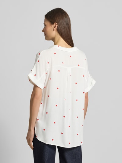 Modelka kobieca nosi Comfort Fit Bluse aus reiner Viskose Modell 'BUMPY' von Vero Moda, biała, czerwony wzór serc, delikatna faktura, krótki rękaw, krój comfort fit, widok całej sylwetki z tyłu.