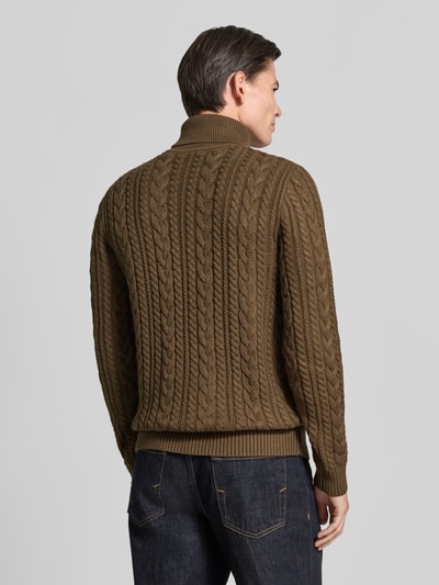 Männermodel trägt Slim Fit Strickpullover mit Baumwoll-Anteil Modell 'Callum' von JACK & JONES, Zopfmuster, braun, Ganzkörperansicht Rückansicht.