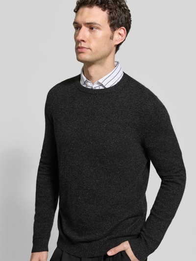 Männermodel trägt Kaschmirpullover mit gerippten Abschlüssen von Christian Berg Men in Anthrazit, glatte Struktur, Nahaufnahme Oberkörper. Reines Kaschmir, gerader Schnitt, Rundhalsausschnitt, Rücken- und Ärmellänge bei Größe M: 72 cm.