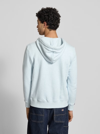 Męski model nosi Regular Fit Sweatjacke mit Logo-Stitching od Superdry, kolor jasnoniebieski, mieszanka bawełny, kaptur z tunelem, zamek błyskawiczny, kieszeń kangurka, elastyczne wykończenia, długość tyłu 69 cm, długość rękawów 65 cm, widok całej sylwetki z tyłu.