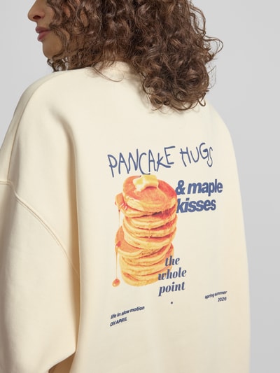 Frauenmodel trägt Oversized Sweatshirt mit Logo-Stitching Modell 'Pancake' von OH APRIL, mieszanka bawełny, krój oversized fit, okrągły dekolt, elastyczne wykończenia, damska bluza, jasny kolor, tekstura miękka, nadruk z tyłu, Ganzkörperansicht Rückansicht.
