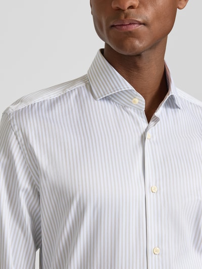 Männermodel trägt Slim Fit Businesshemd aus reiner Baumwolle Modell 'HANK' von BOSS, gestreift, Haifischkragen, Nahaufnahme Oberkörper.