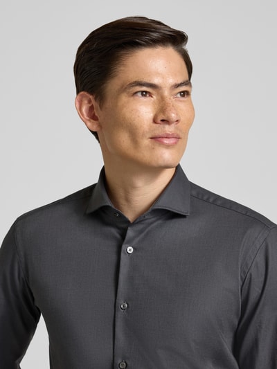Männermodel trägt Regular Fit Businesshemd aus Baumwoll-Mix Modell 'H-JOE-SPREAD' von BOSS, unifarben, Kentkragen, Nahaufnahme Oberkörper.