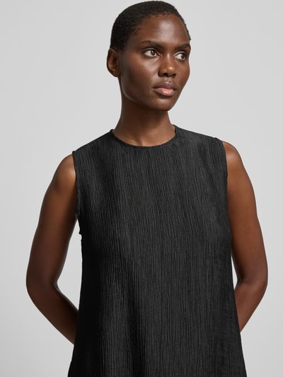Frauenmodel trägt Relaxed Fit Top aus Viskose-Mix von Anine Bing mit Rundhalsausschnitt, Strukturmuster, ärmelloses Design, Nahaufnahme Oberkörper.