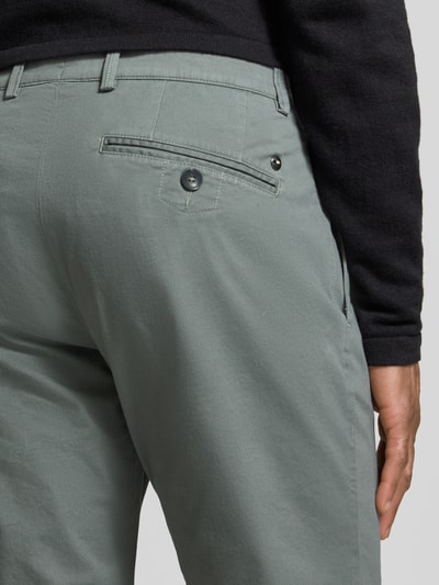 Männermodel trägt Fein strukturierte Chino mit Gesäßtaschen von bugatti, grün-grauer Baumwoll-Mix, Detailaufnahme Gesäßpartie.