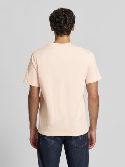 Männermodel trägt Regular Fit T-Shirt aus reiner Baumwolle von Lacoste in zartem Rosa, klare Linien, glatte Textur, Ganzkörperansicht Rückansicht. Herren T-Shirt von Lacoste.