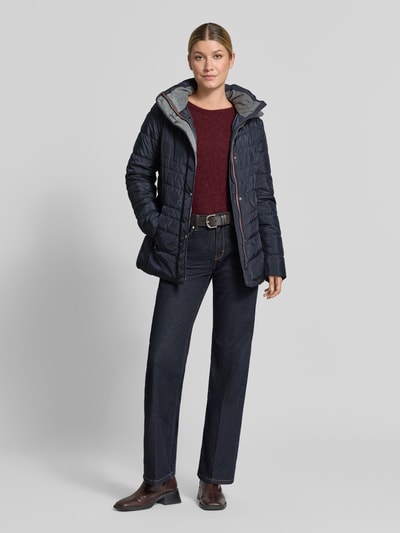 Vrouwenmodel draagt Jacke in Stepp-Optik met Kapuze van FUCHS SCHMITT in donkerblauw met stiksels, getailleerd, steekzakken met ritssluiting, gevoerde opstaande kraag, ruglengte maat 36: 74 cm, schouderbreedte: 40 cm, borstwijdte: 48 cm, mouwlengte: 64 cm, full body vooraanzicht.