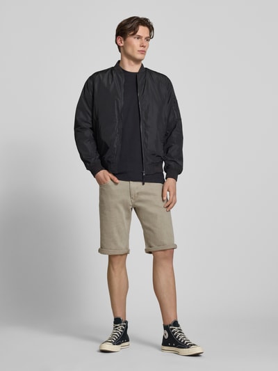 Männermodel trägt Jeansshorts mit Eingrifftaschen Modell 'Mosa' von G-Star Raw aus Baumwoll-Elasthan-Mix, Regular-Fit, Ganzkörperansicht von vorne.