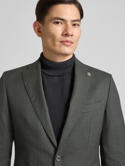 Männermodel draagt 2-knoops colbert van zuivere scheerwol, regular fit, model 'Corsin' van CG - Club of Gents, borstzak, klepzakken, labeldetail, knoopsluiting, reverskraag, kleur donkergrijs, textuur fijn geweven, nahaufnahme bovenlichaam. Ruglengte maat 50: 72 cm, schouderbreedte: 42 cm, mouwlengte: 65 cm.